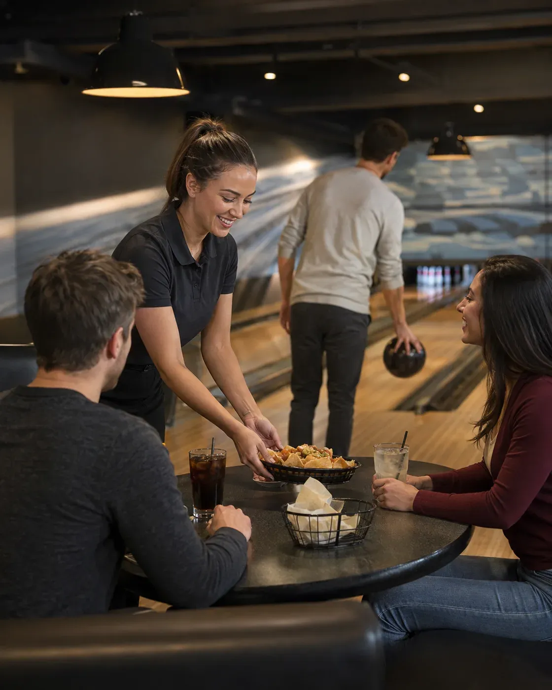 Illustrative Szene eines Mitarbeiters, der einer weiterspielenden Gruppe an der Bowlingbahn Snacks und Getränke bringt.