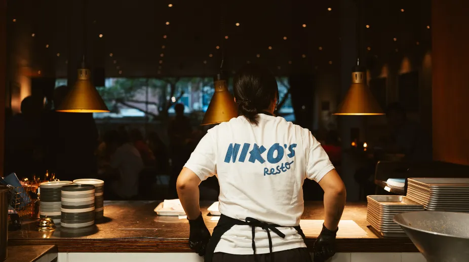 Een medewerker aan de open keuken van Niko’s Resto bij KINO in Rotterdam.